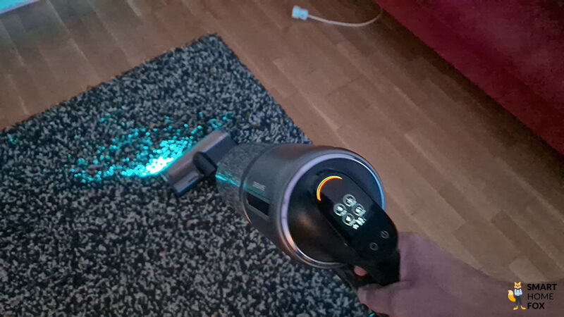 Die Dreame Z40 Station im Einsatz auf einem Teppichboden mit aktivierter Blaulichtausleuchtung und sichtbarem Display im Ultra Modus.